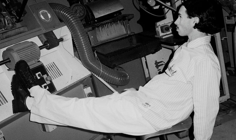 black and white image with model sitting on a chair in factory