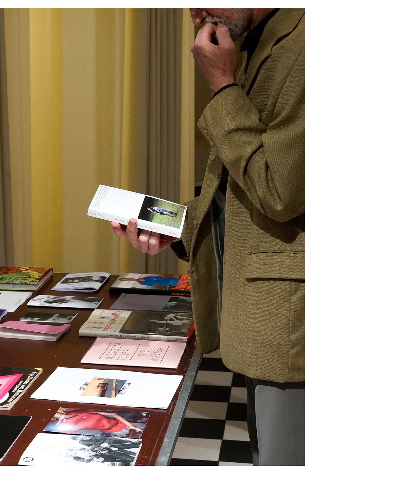 man holding a book looking at the back cover