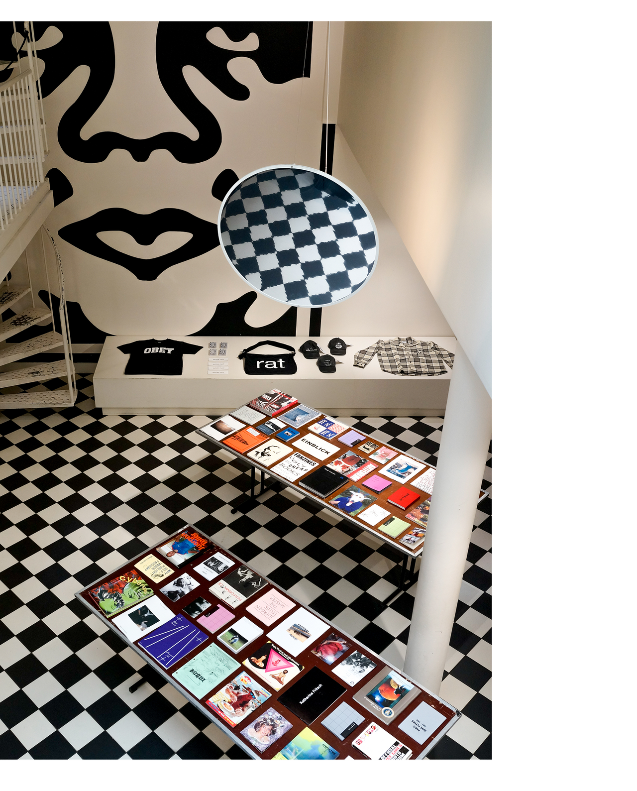 Obey amsterdam store with tables with books. Icon face in the background